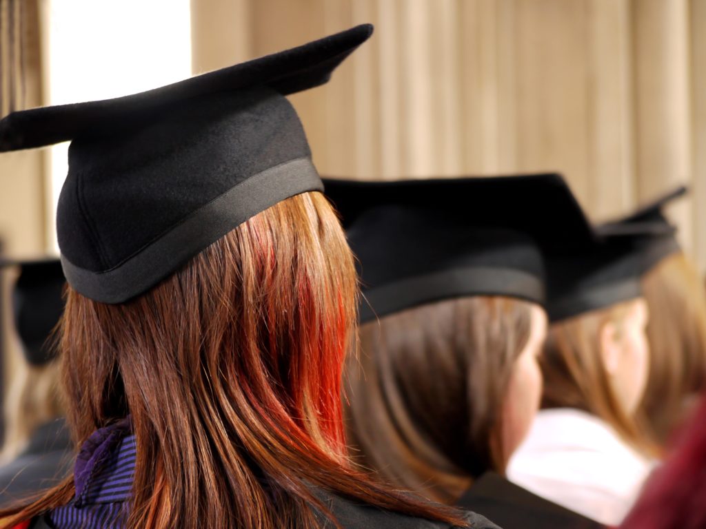 A row of students wearing mortarboard caps at their graduation