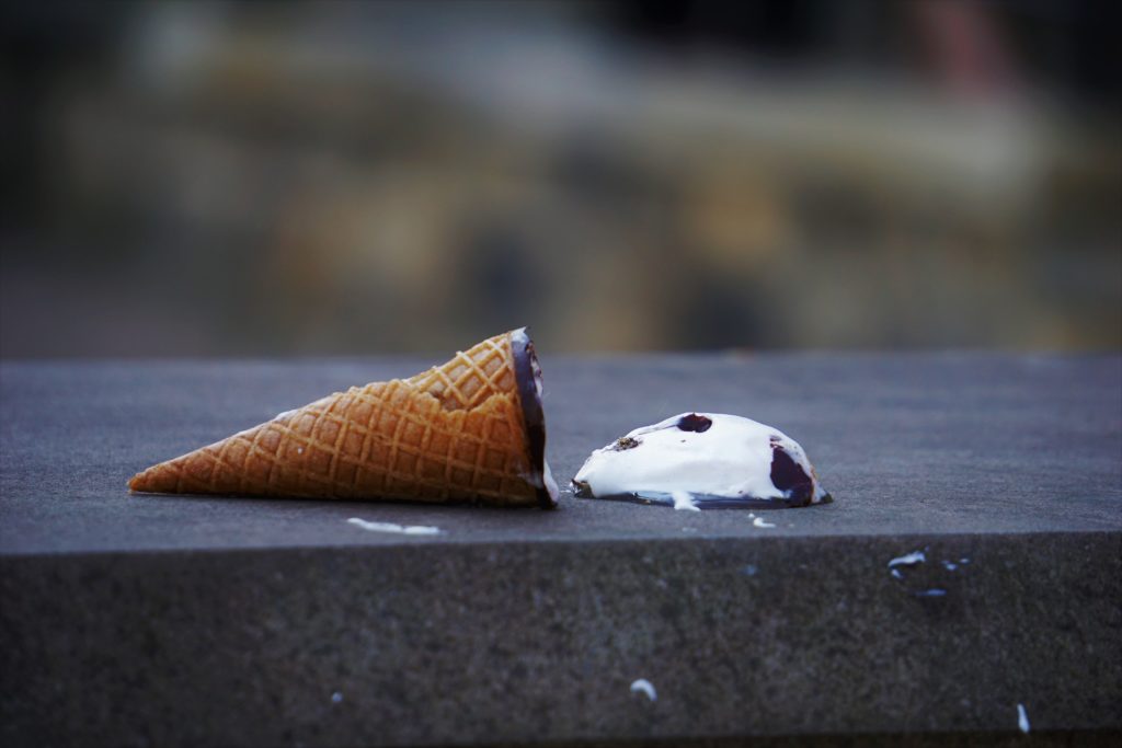 Some ice cream fallen out of it's cone.